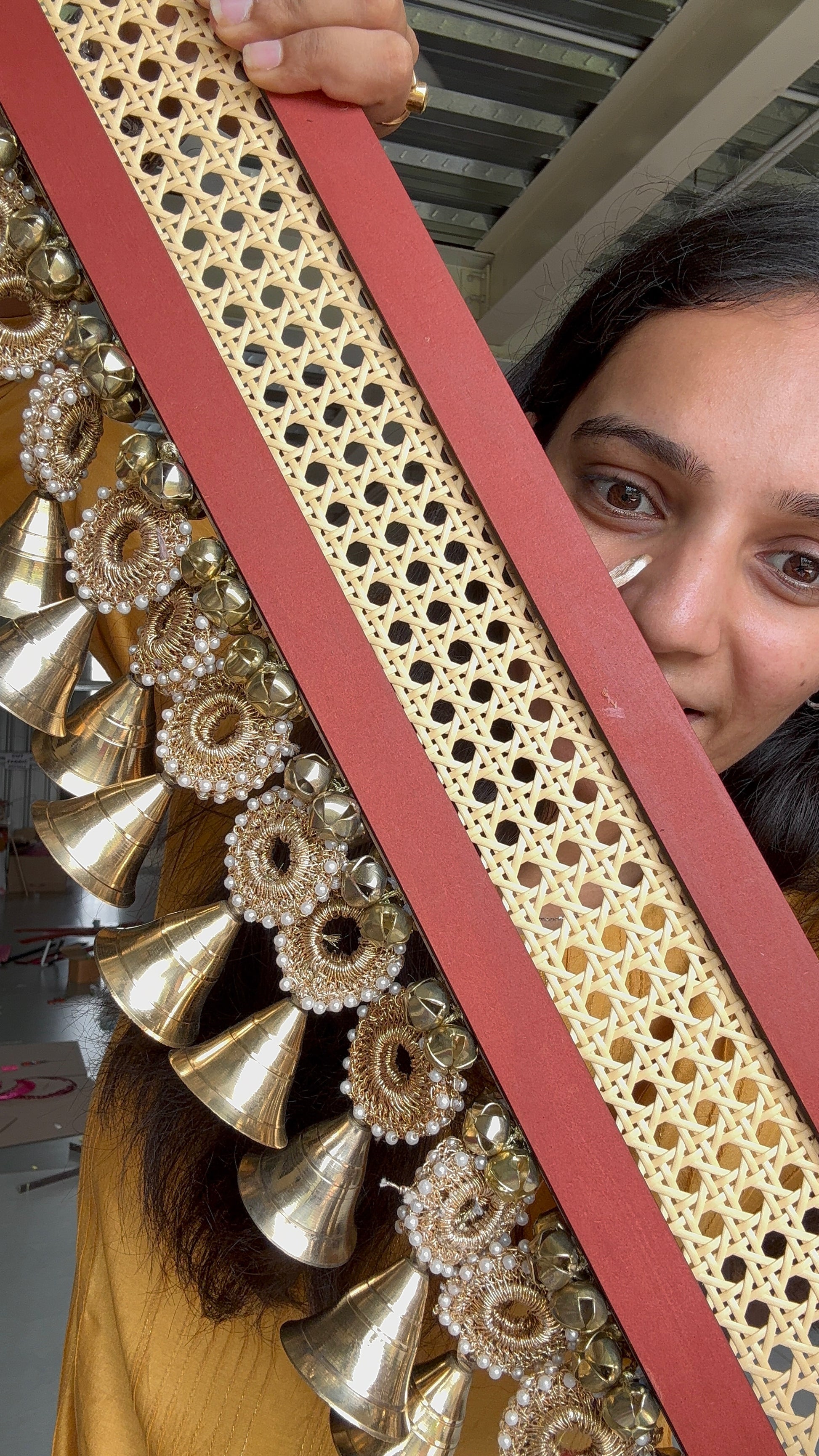 IBHI Navya Shobhā Toran with brass bells, rattan, crochet, and handpainted red panel – modern handcrafted décor