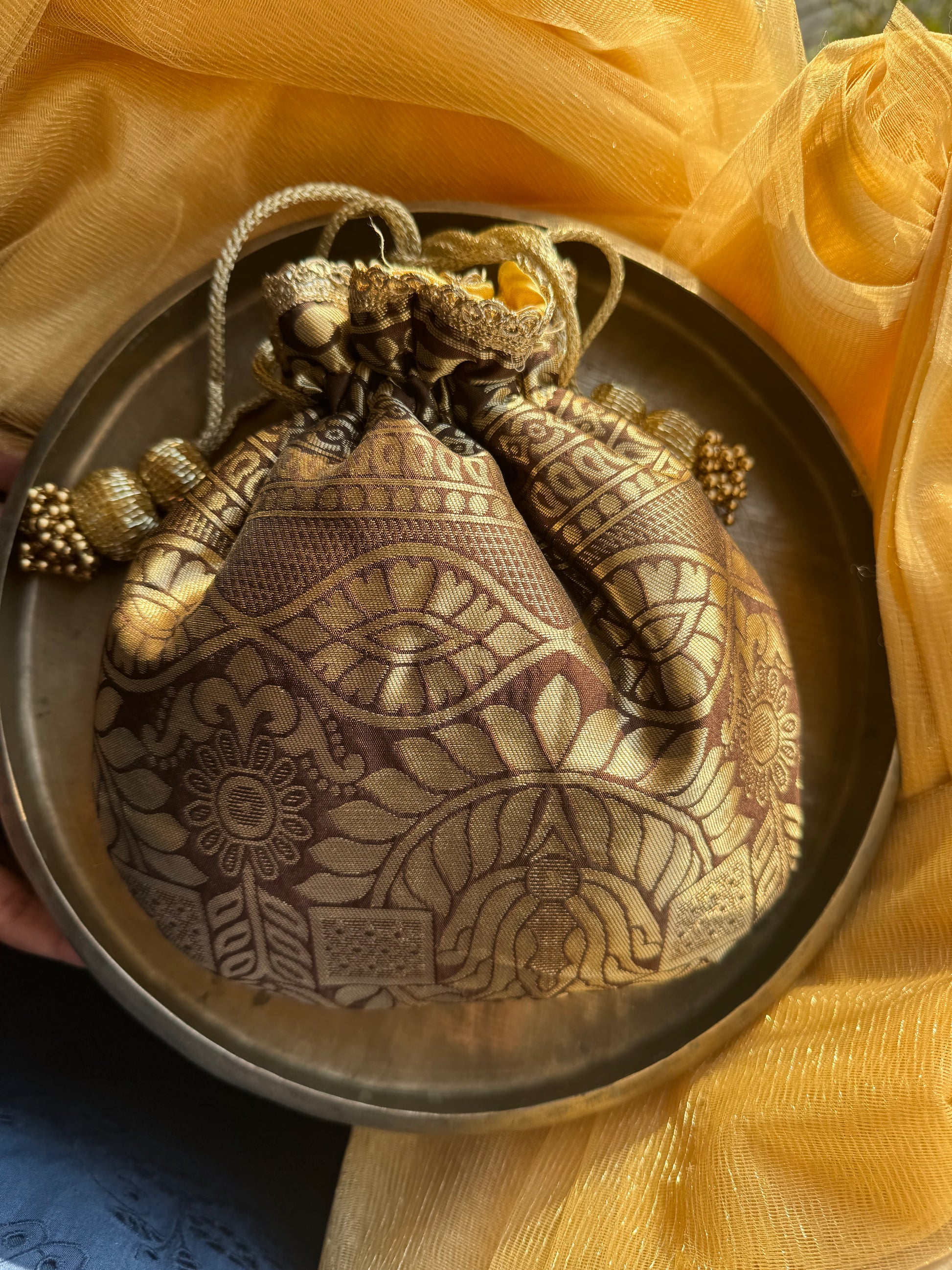 DhoopSona potli bag in deep brown and gold – handmade and softly padded, perfect for wedding favors and festive Indian gifting.