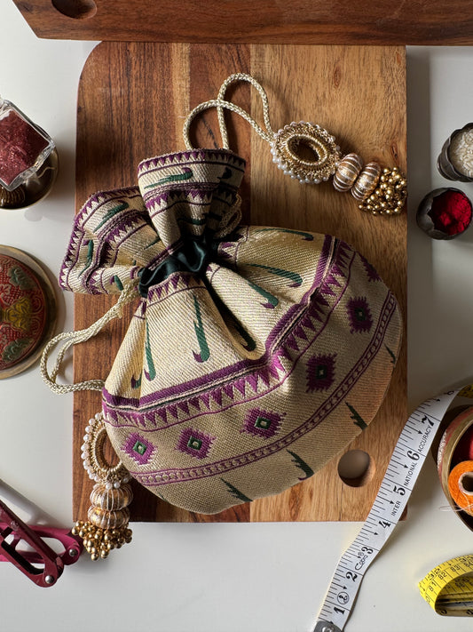 Deep purple Paithani potli bag with golden zari weave and drawstring closure – perfect for wedding gifting and festive return favors by IBHI.