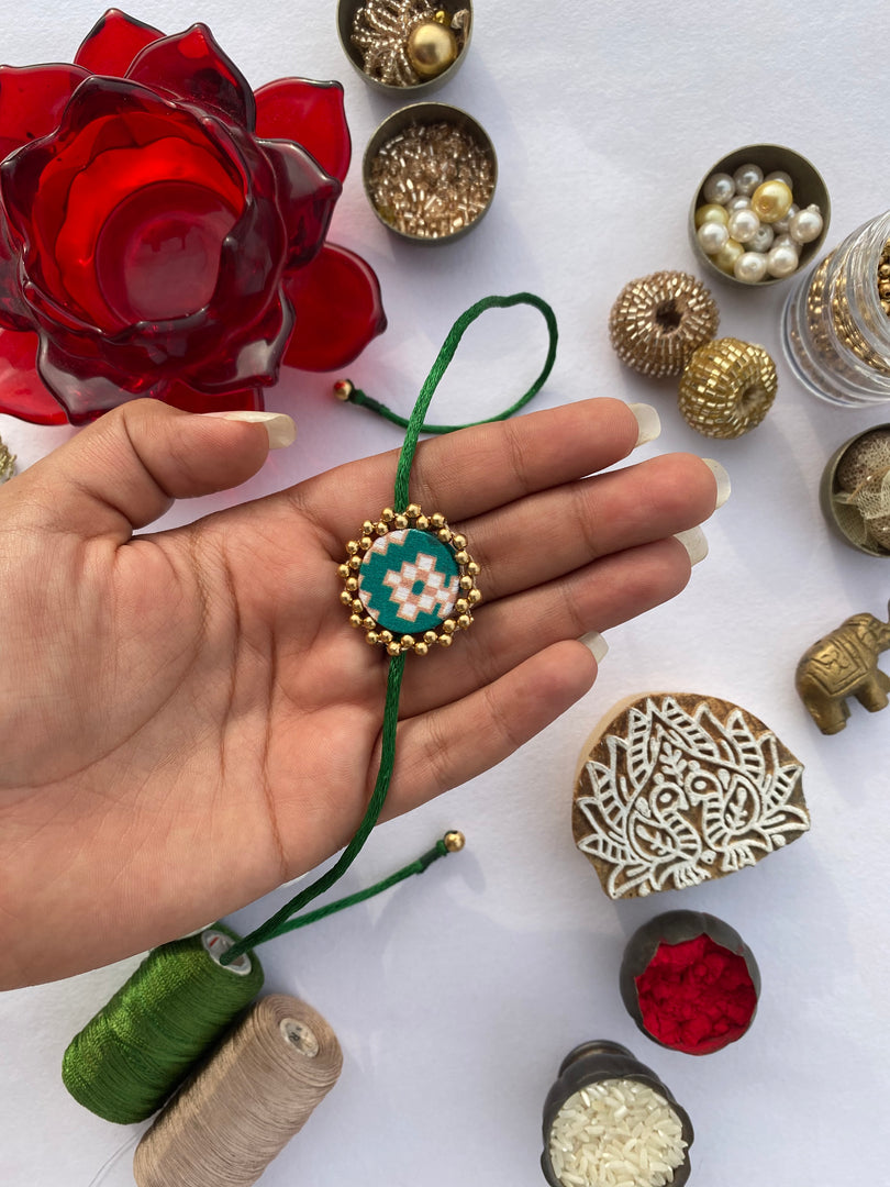 Miniature Maroon Navratna Patola Beaded Emblem Rakhi