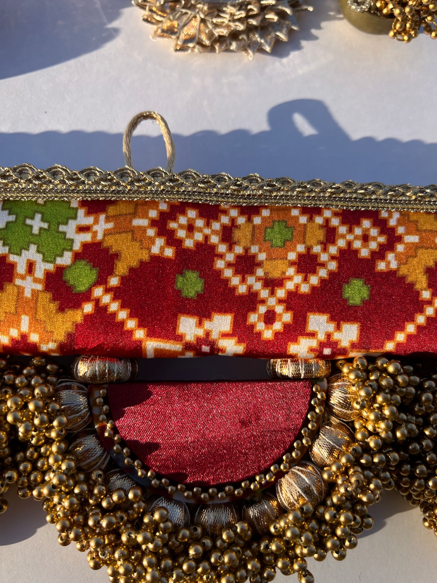 THE SLEEK: Maroon Navratna Patola X Solid Beaded Arcs and Inflorescence Divine Pichwai Toran for home decor