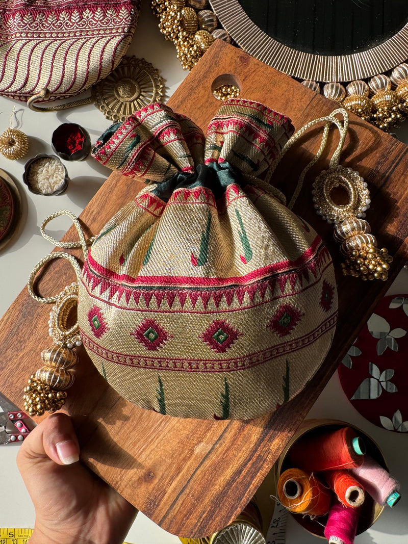 Maroon Paithani potli bag with golden zari weave and drawstring – ideal for wedding favors and festive return gifting. Named Shahi Kumkum by IBHI.

