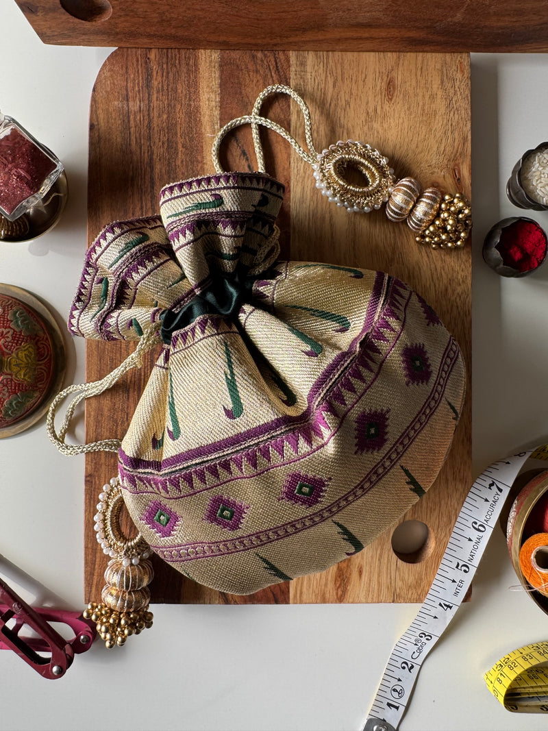 Deep purple Paithani potli bag with golden zari weave and drawstring closure – perfect for wedding gifting and festive return favors by IBHI.

